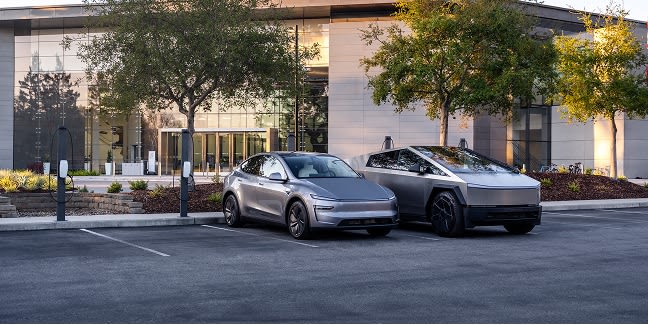 A Quicksilver Model Y and a Cybertruck charging at Wall Connectors surrounded by industrial buildings