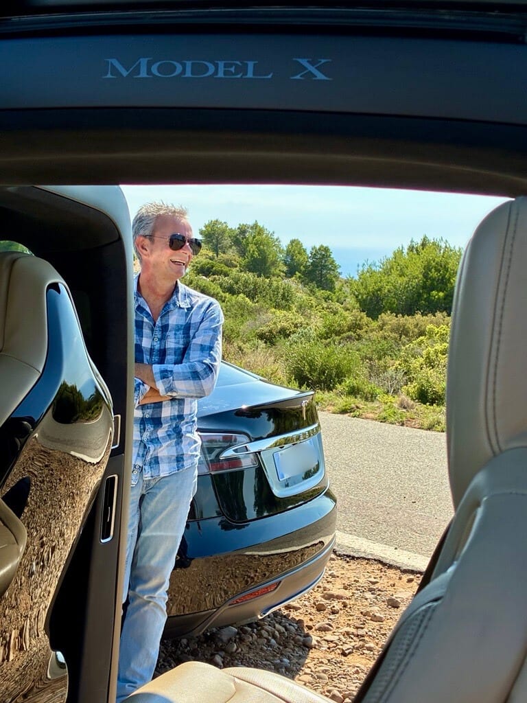 Jarod standing next to his Tesla vehicles