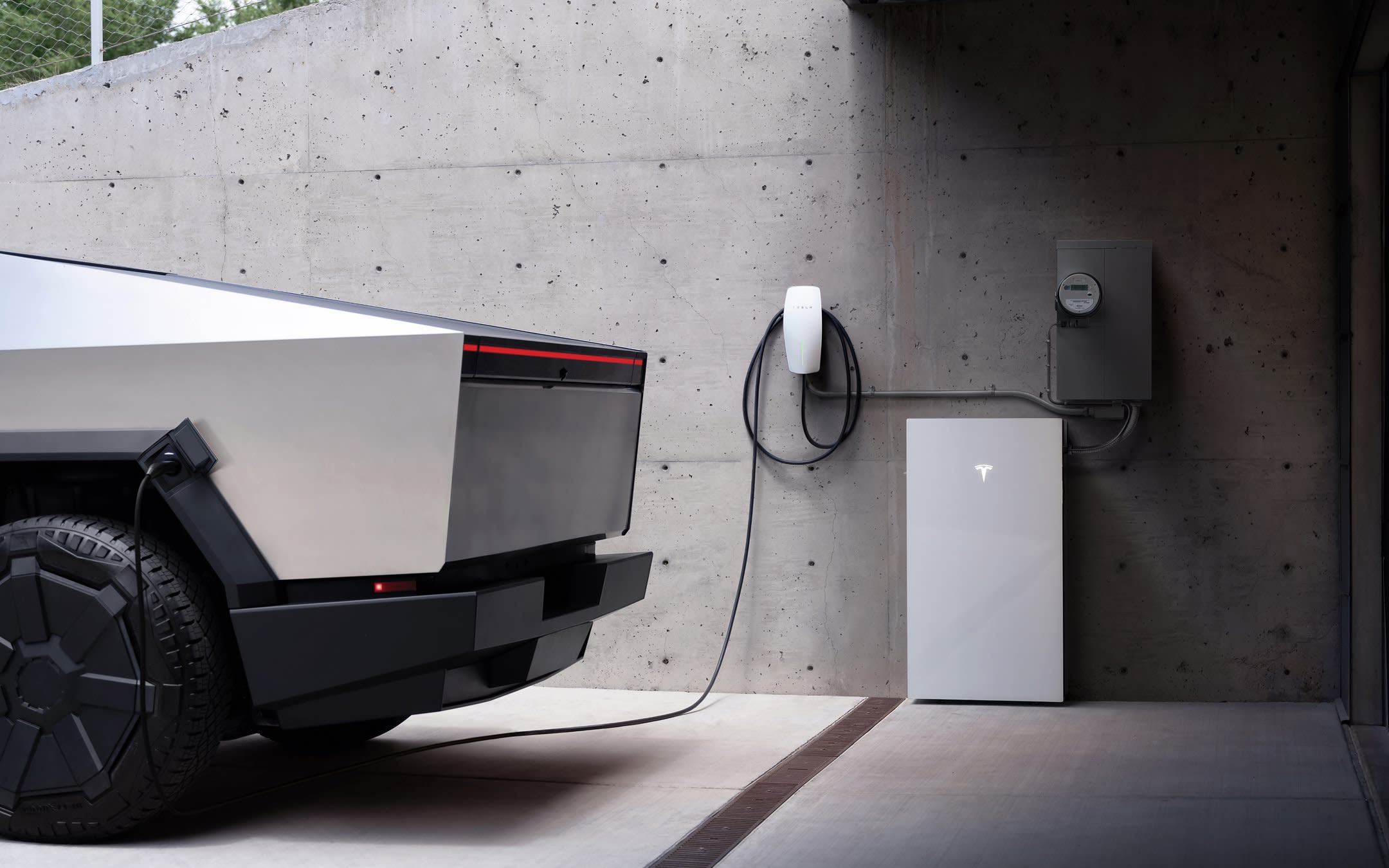 White Model Y charging at a Wall Connector in a home's driveway