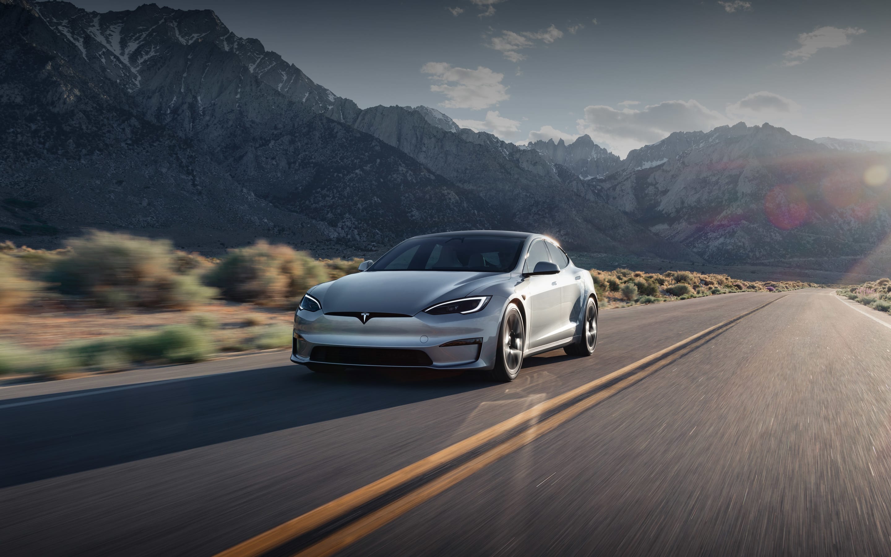 Model S negro sólido acelerando en una autopista elevada	