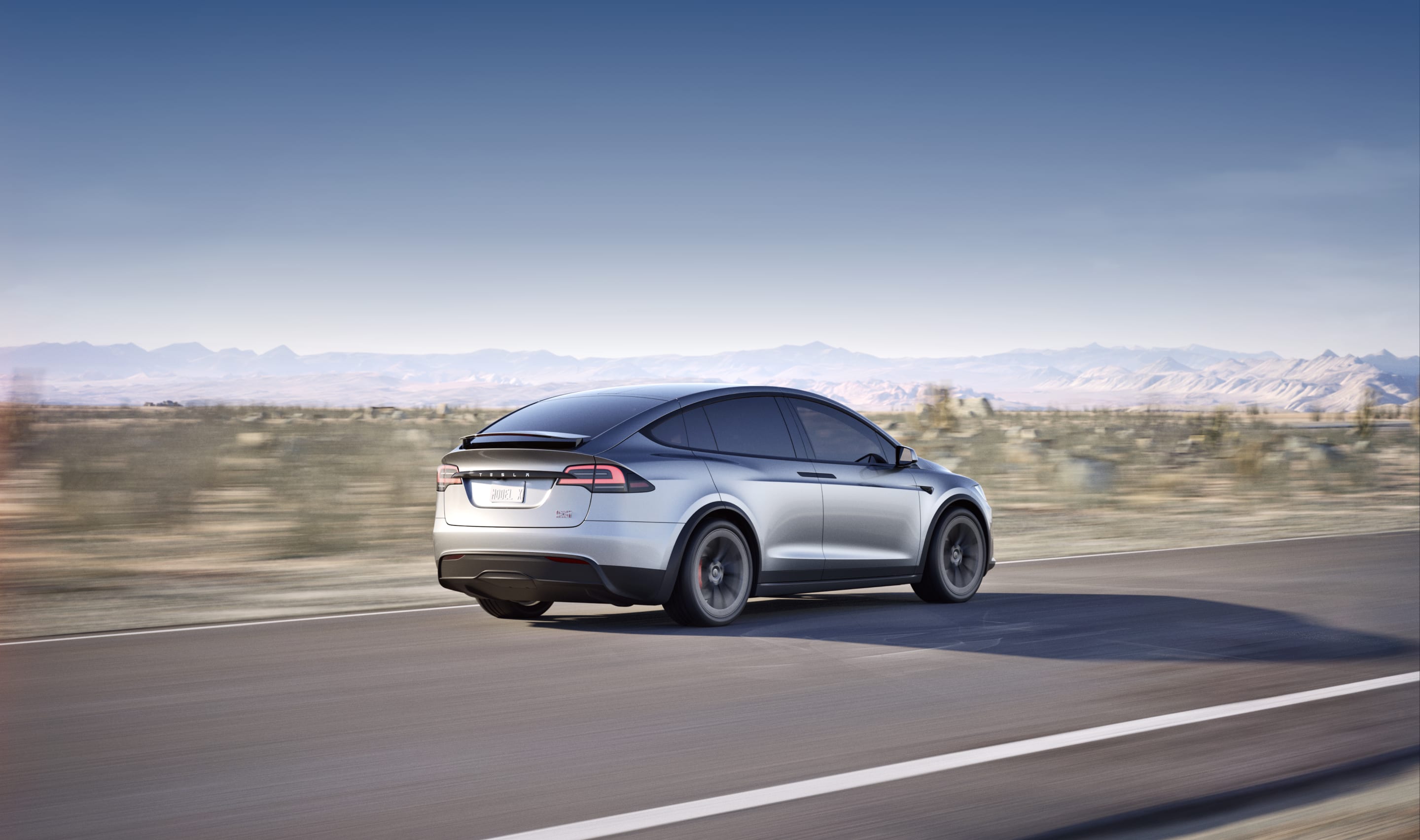 Pearl white Model X navigating a mountainous road