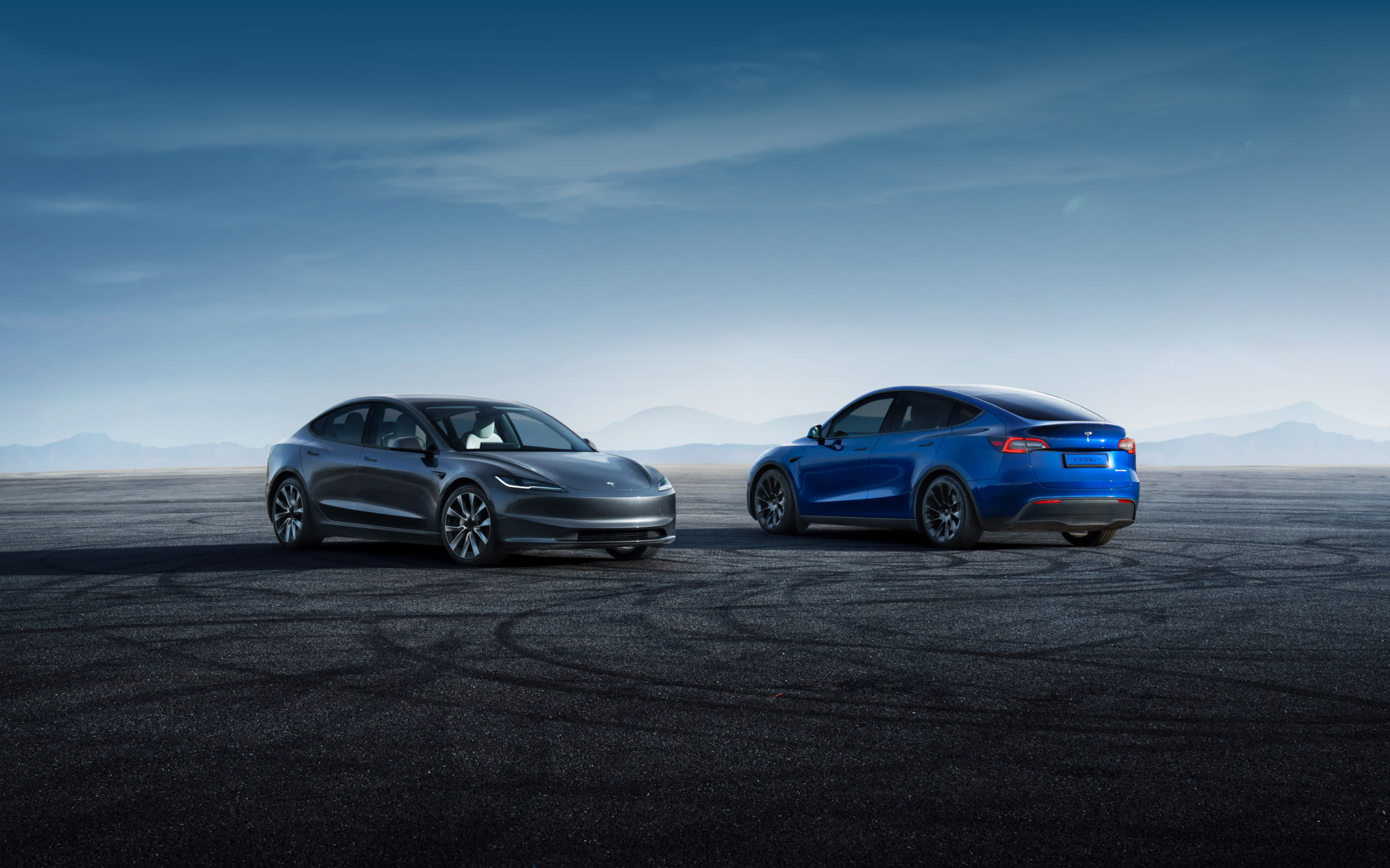 Parked Stealth Grey Model 3 and Deep Blue Metallic Model Y