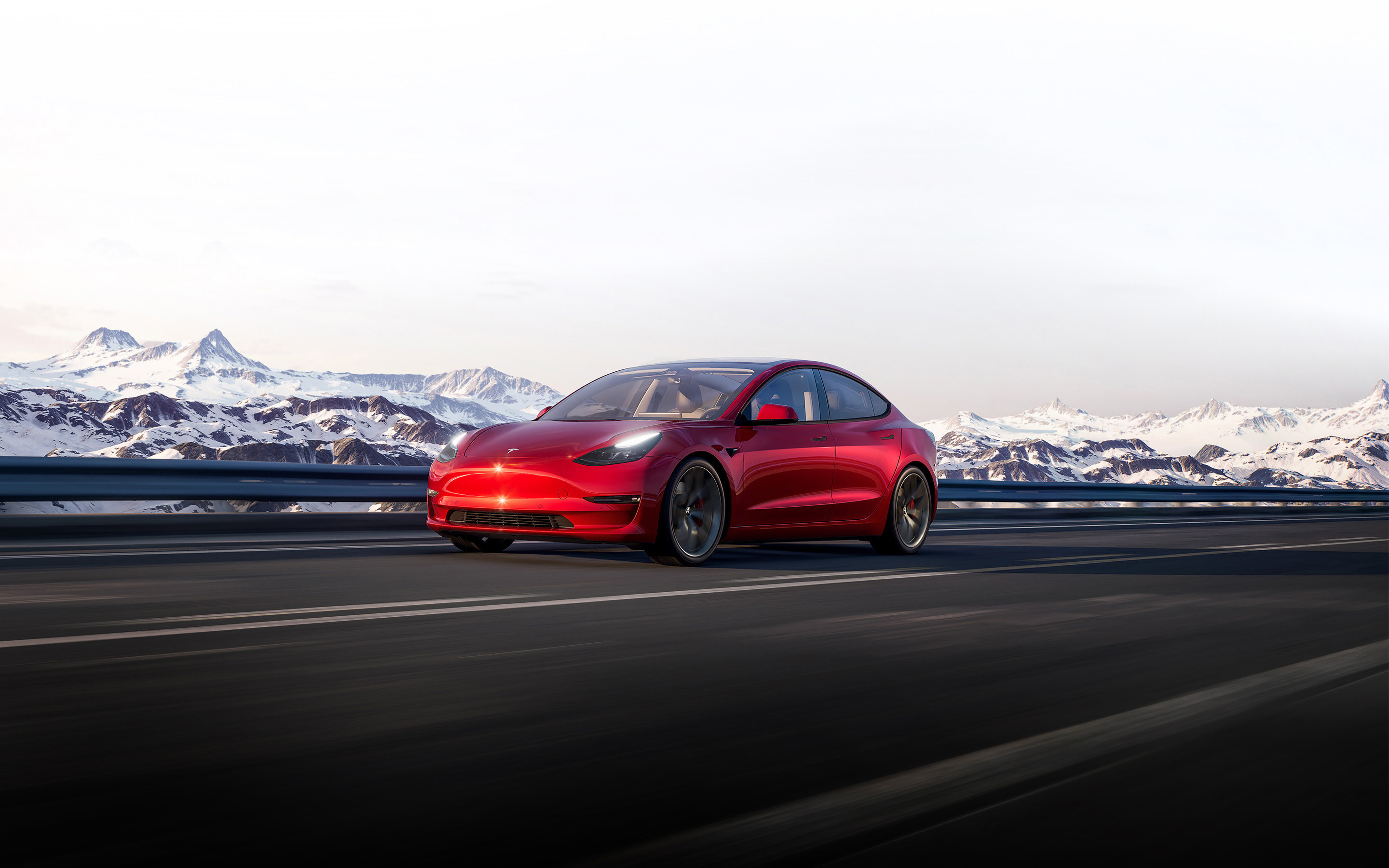Red Model 3 driving down a mountainside road