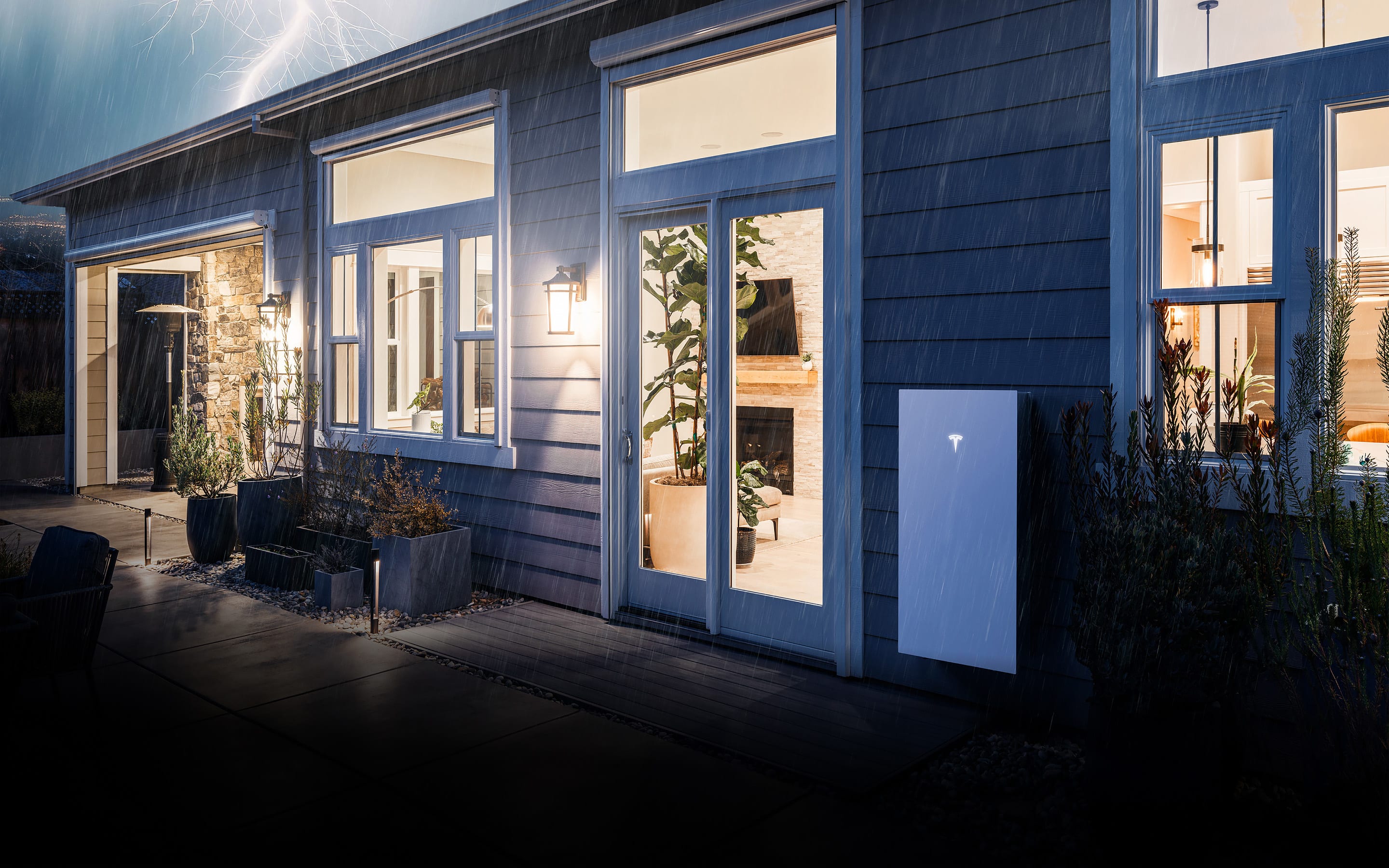 Home lit up during a storm with a Powerwall 3 installed outside