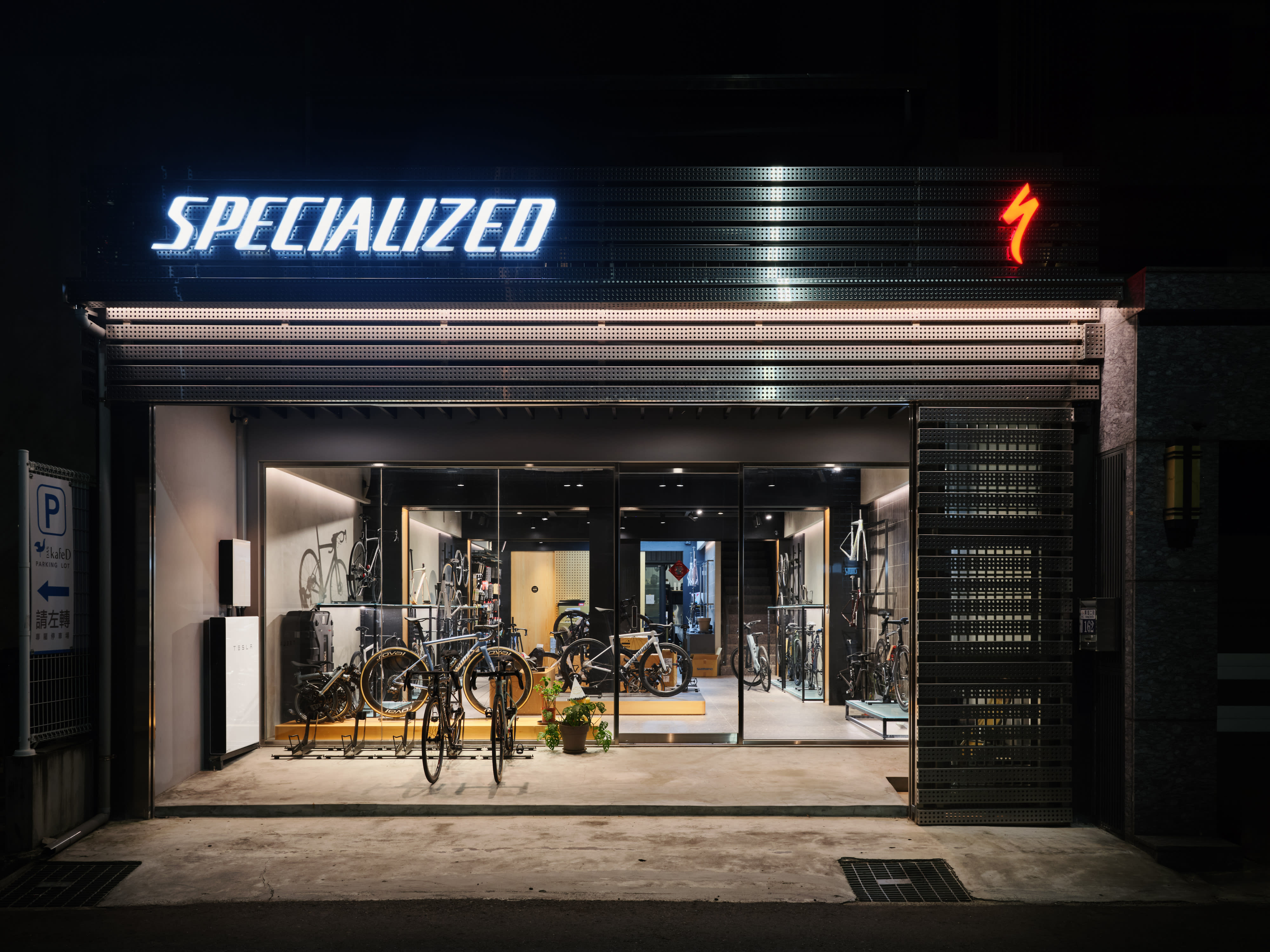 在夜裏，裝有白色 Tesla Powerwall 的自行車店鋪