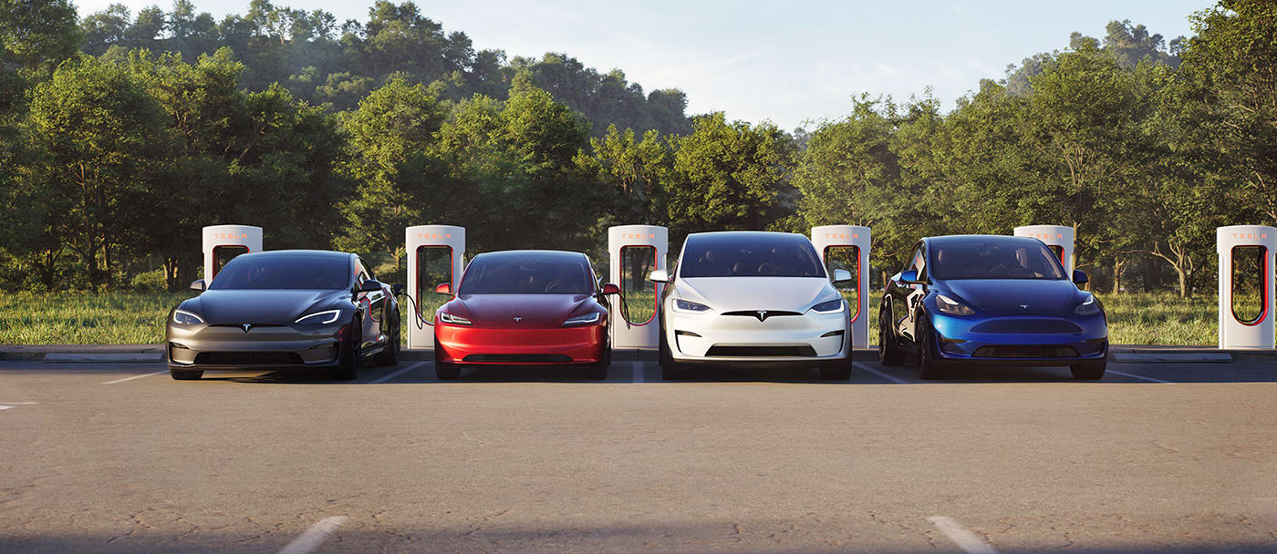 Um Model S cinzento, um Model 3 vermelho, um Model X branco e um Model Y azul a carregar num parque de estacionamento