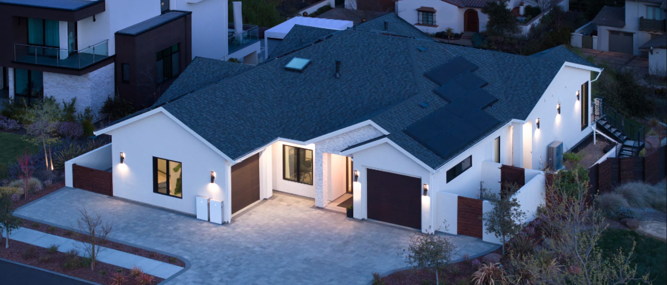 Aerial shot of a white home with solar panels at night