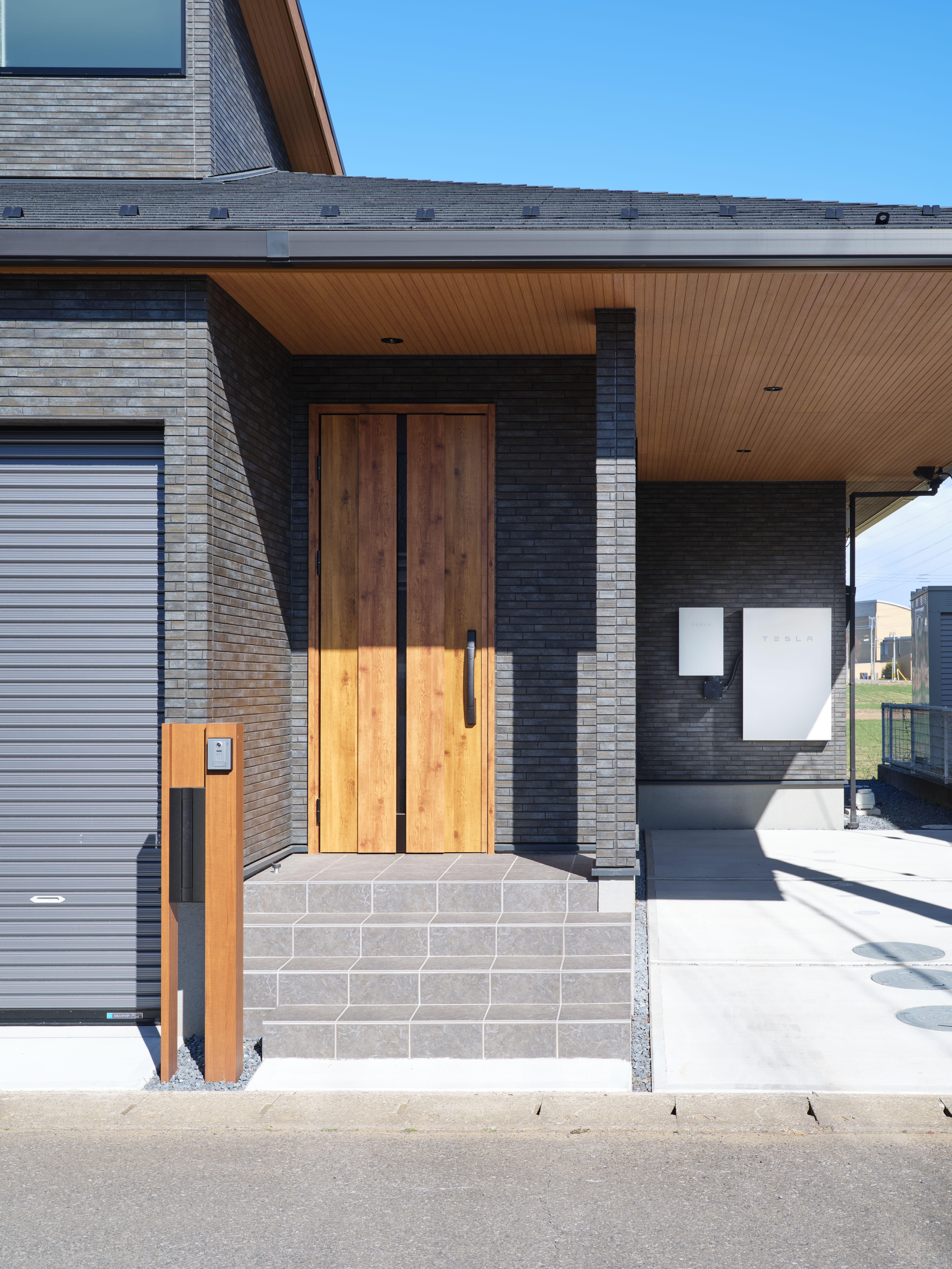Door to a house during the day with Tesla Powerwall in the background