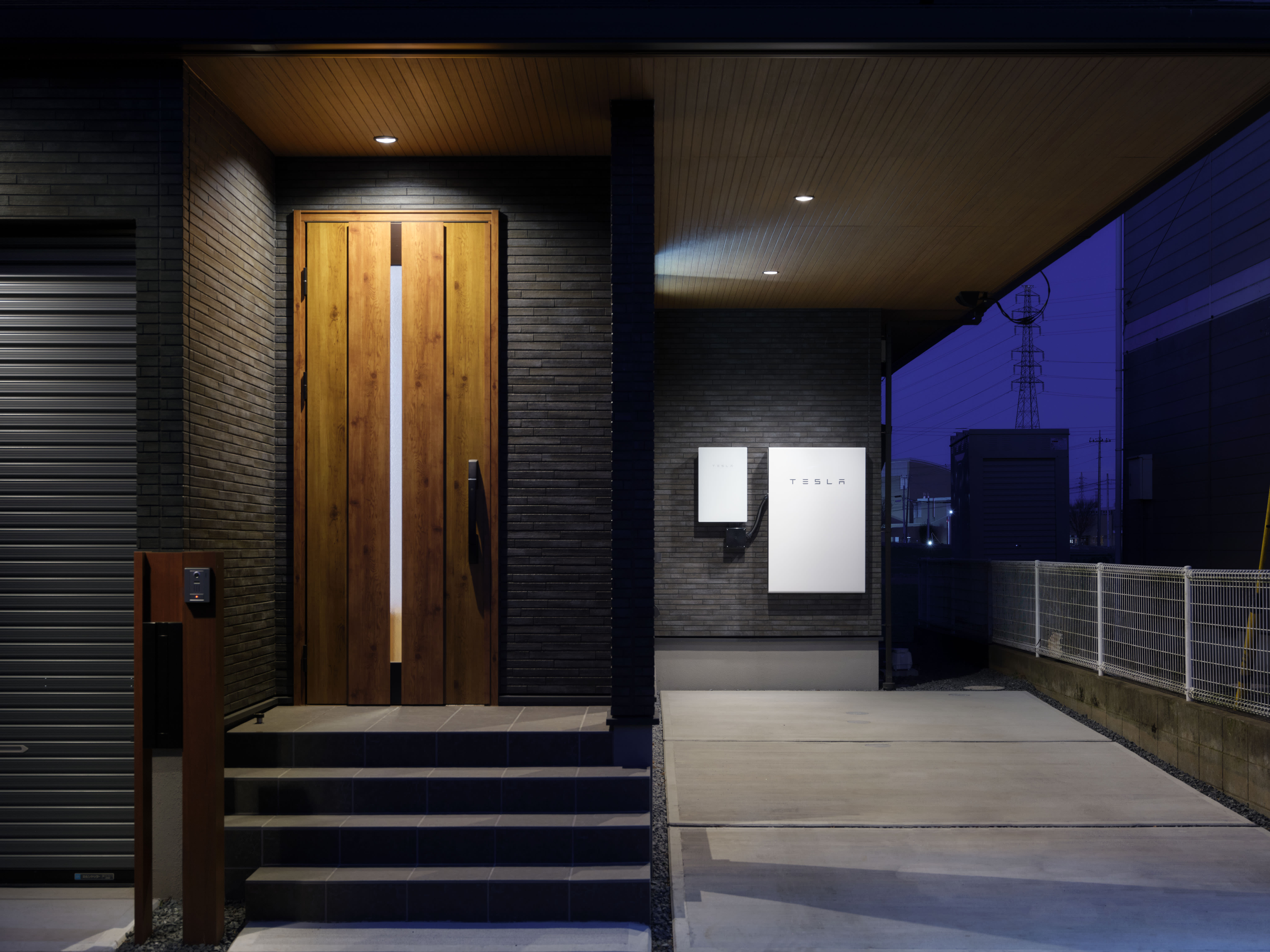 Door of a home at night with Tesla Powerwall in the background