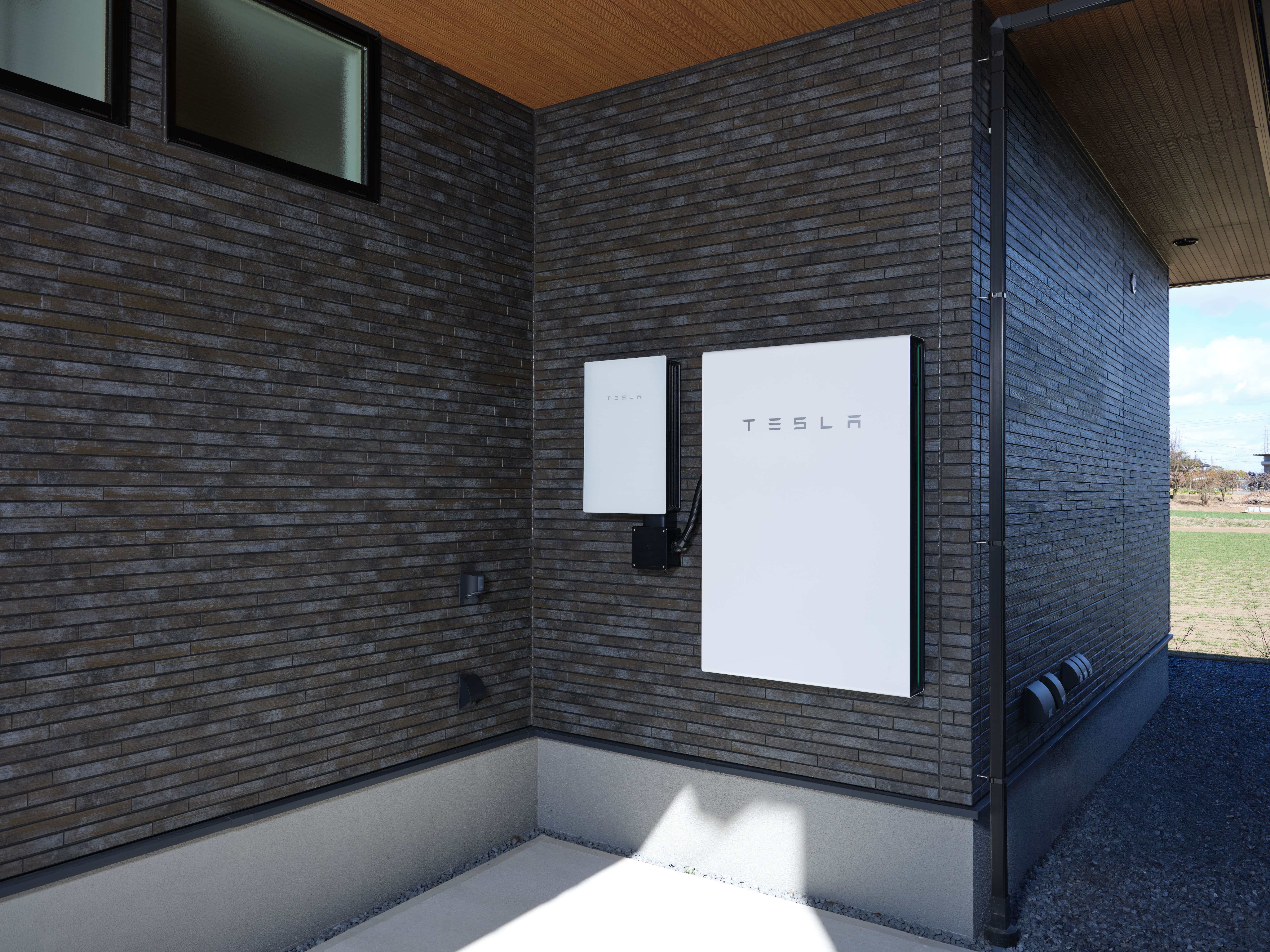 White Tesla Powerwall mounted on the wall of a home