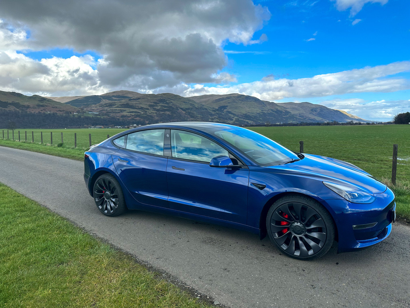 Deep Blue Metallic Model 3 Performance parked in the countryside 