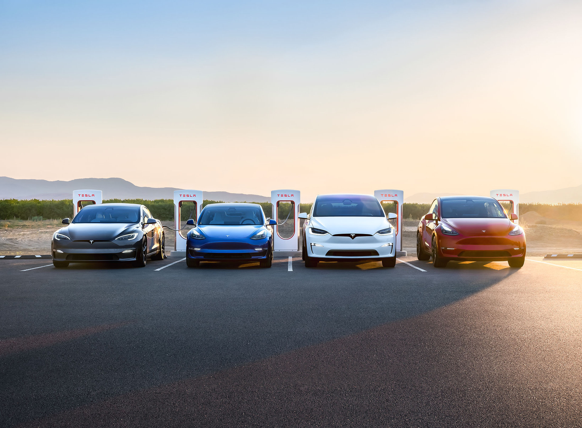 4 Tesla biler, der oplader ved Supercharger ladestationer på et bjerg
