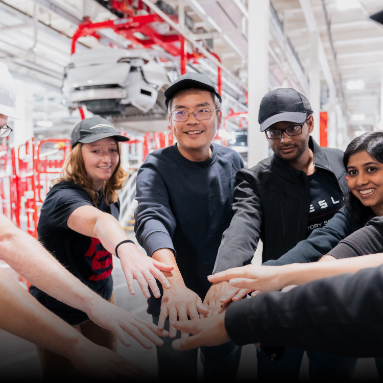 Service employees (both male and female) putting their hands together and laughing while in the workplace