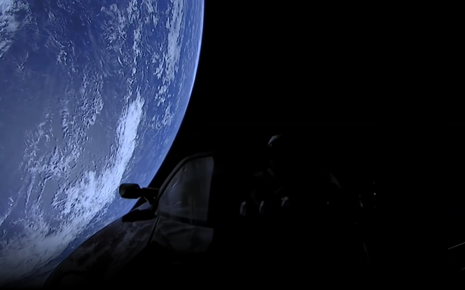 Silhouette of a Roadster in space flying over Earth
