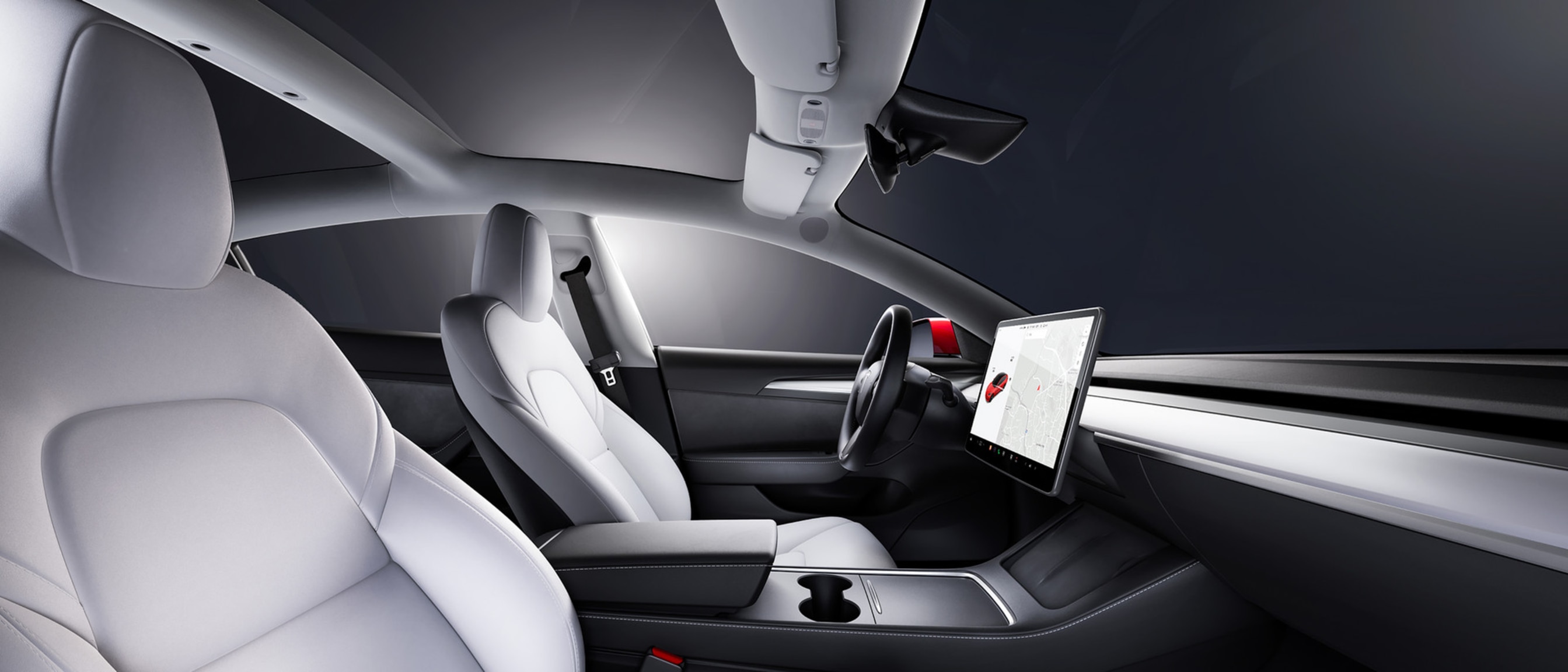 Prikaz prednjih sjedala iz unutrašnjosti vozila Model 3 koja je bijele boje