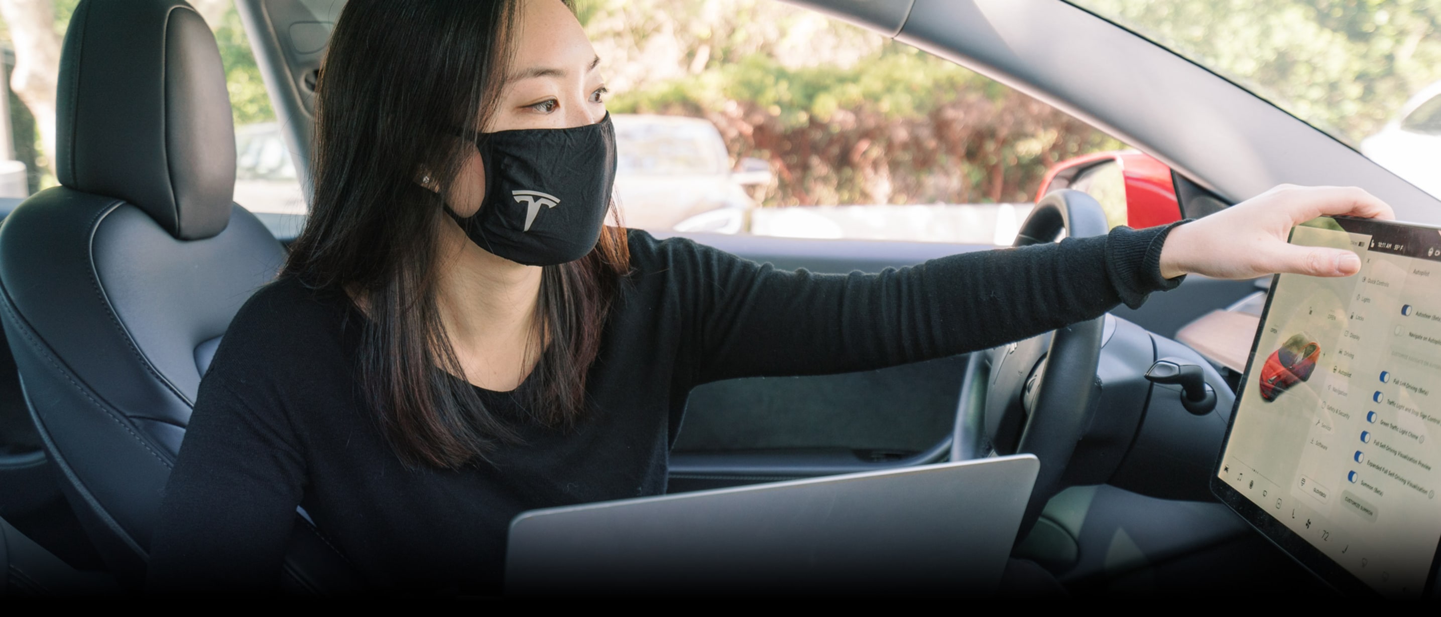 Tesla employees putting their hands together in the Gigafactory