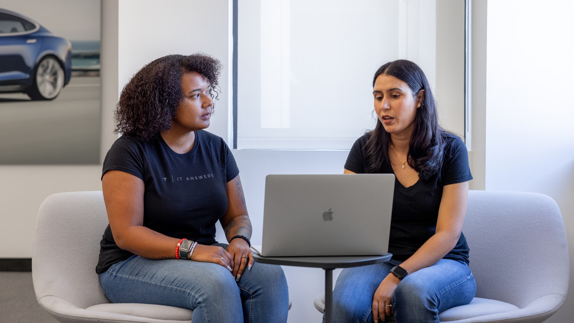 Tesla employees working together on a laptop