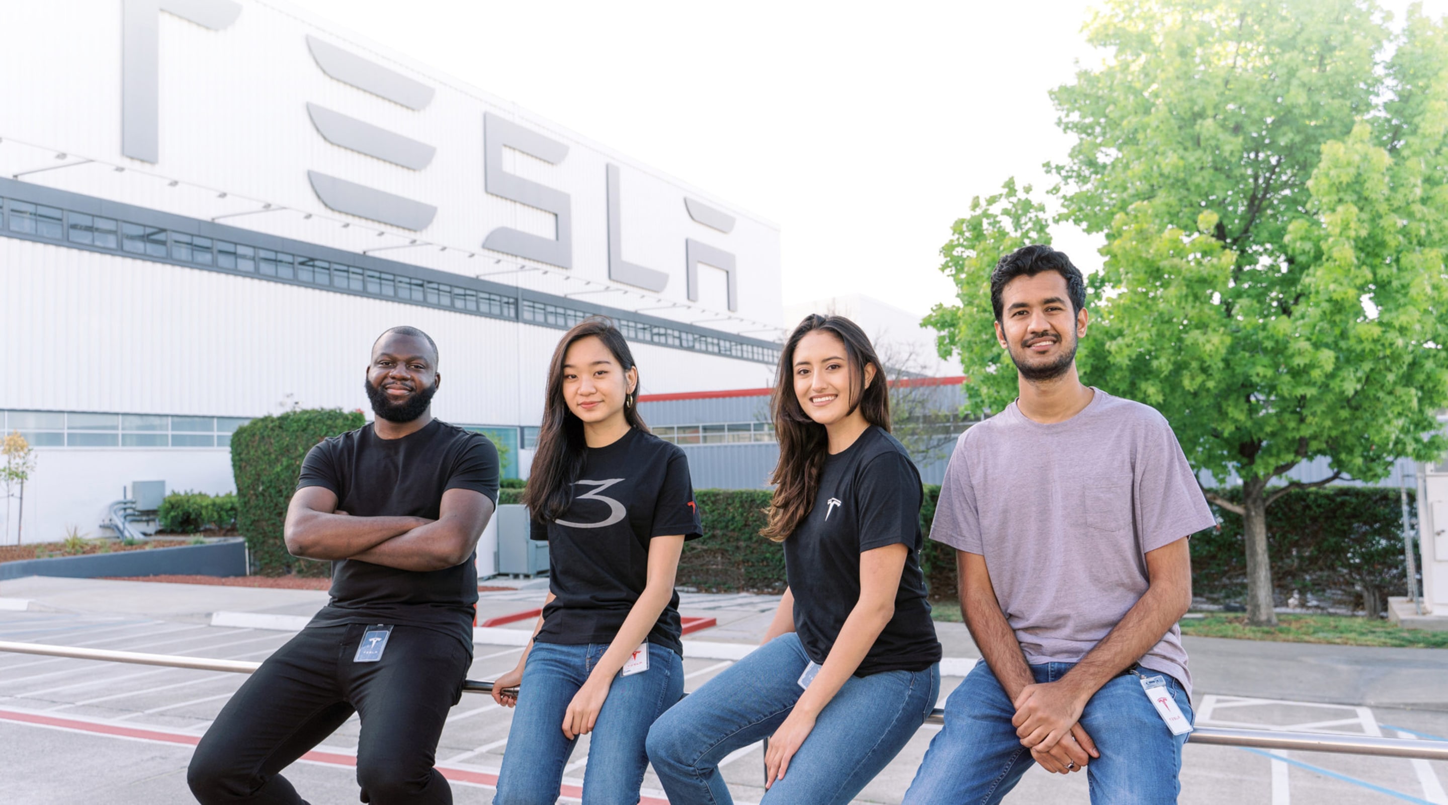 Interns standing in front of Tesla building