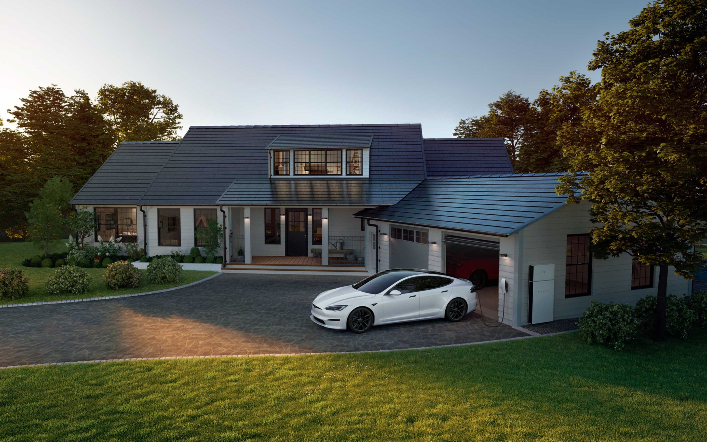 Carga de un Model S blanco a través del Wall Connector en la entrada de una casa