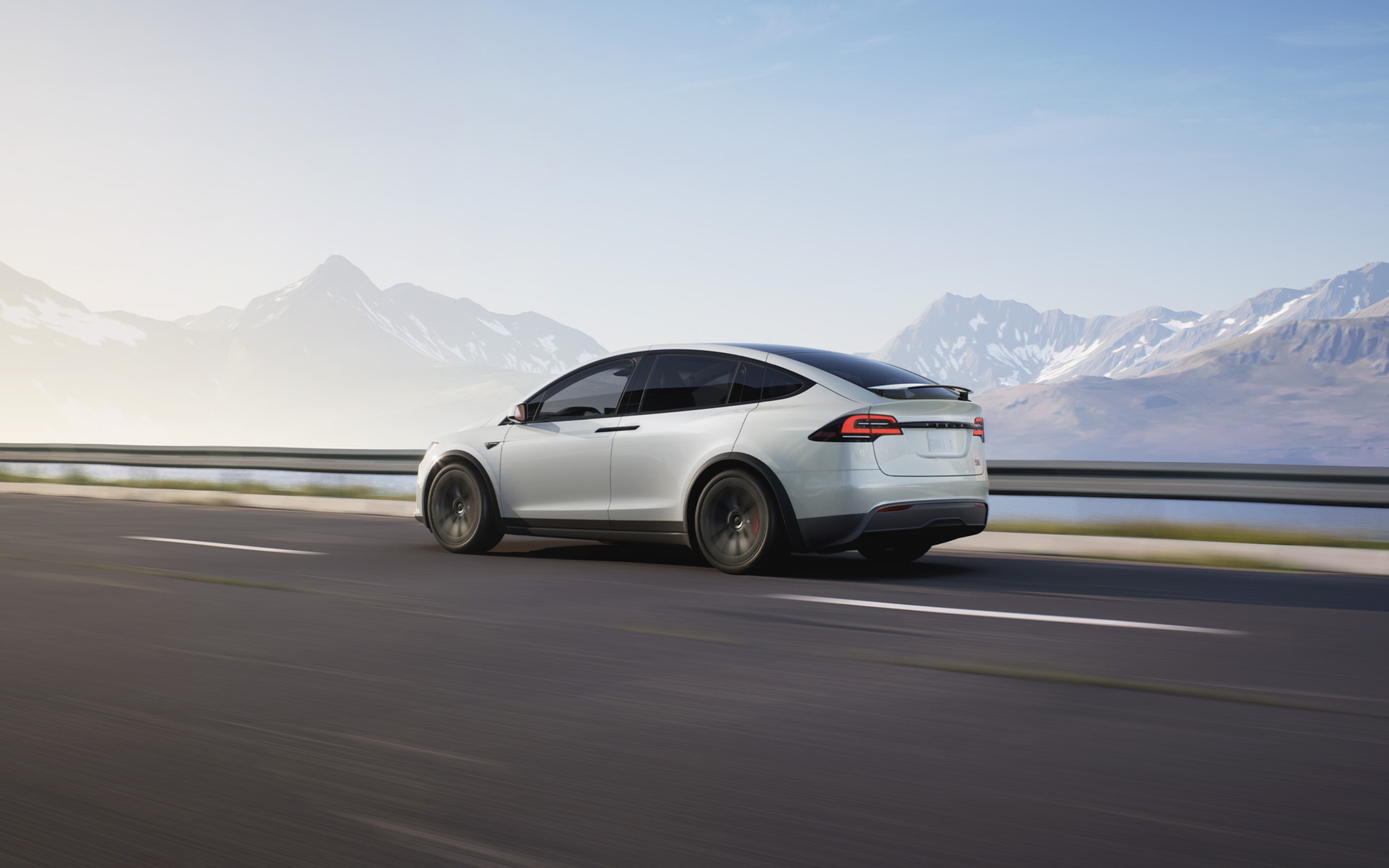 Een Pearl White Model X navigeert op een bergachtige weg