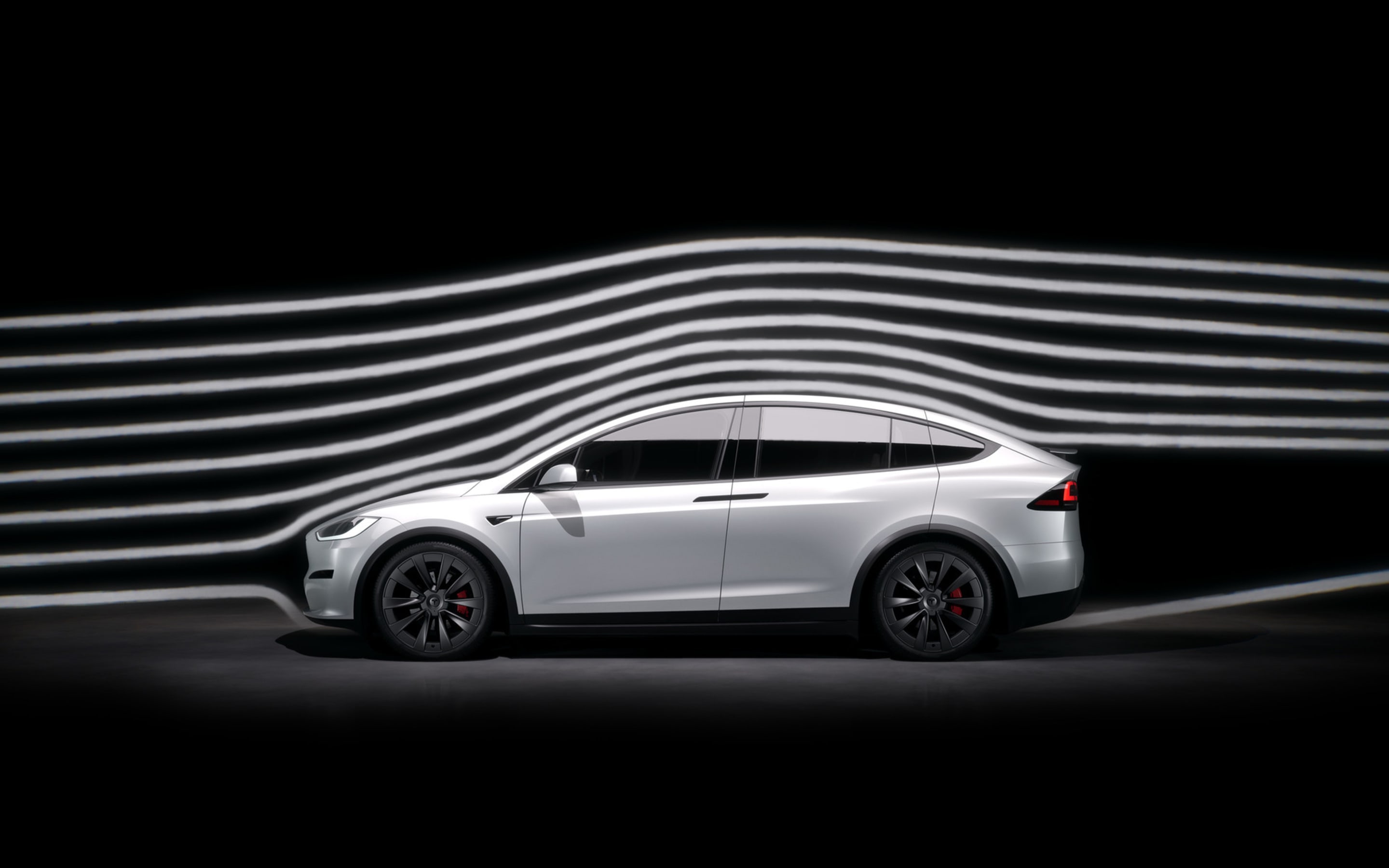 Side view of an Pearl White Model X Plaid with an illustration of the aerodynamic performance