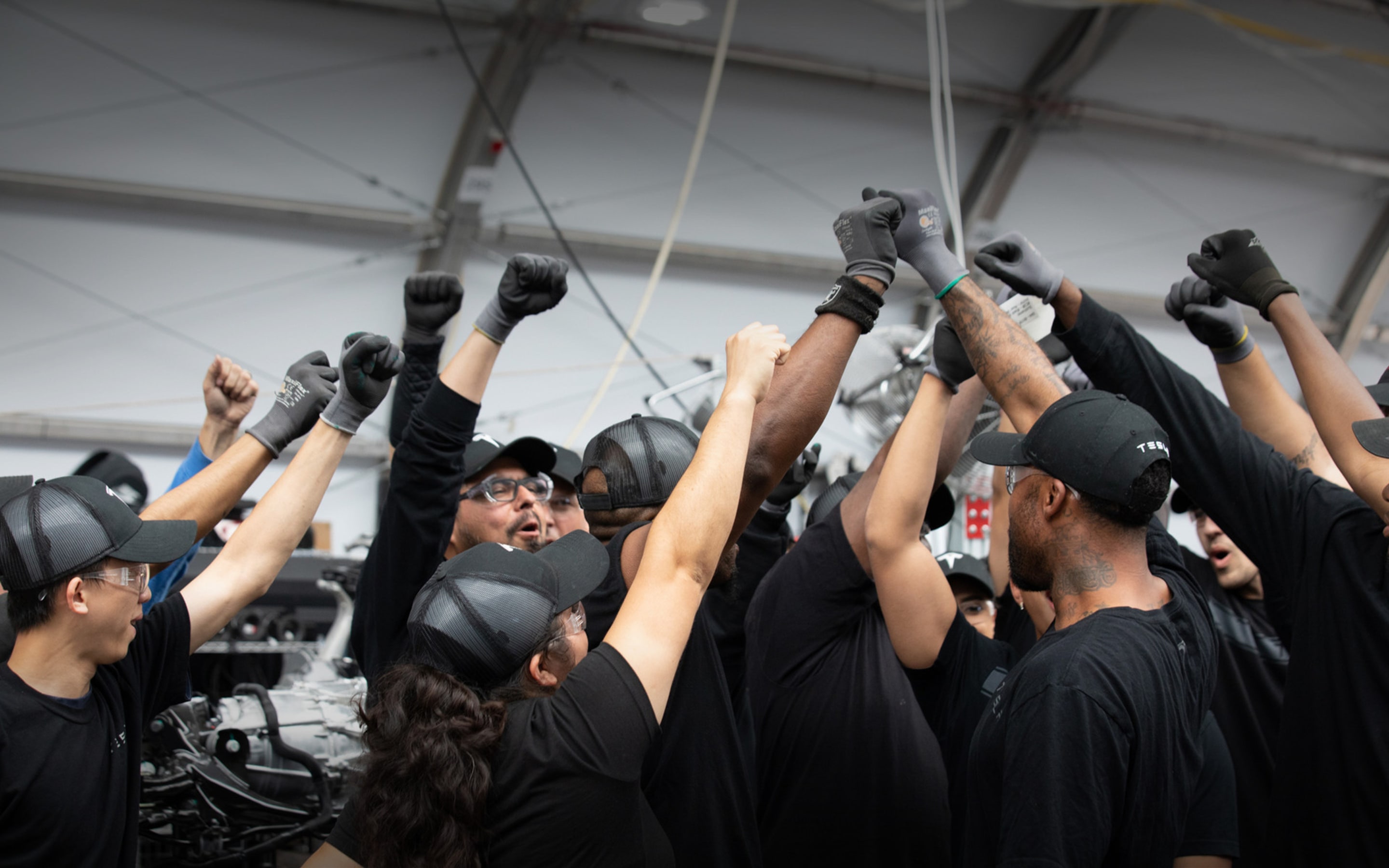 Tesla employees working together in manufacturing facility