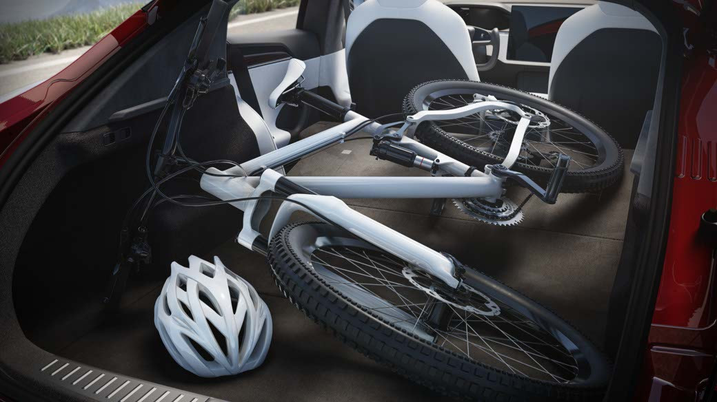 Innenansicht des Kofferraums eines roten Model S mit geladenem weißem Fahrrad und Helm