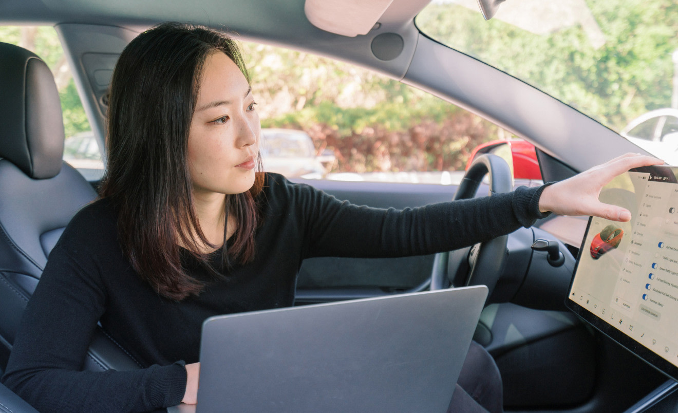 Intern with laptop inside Tesla vehicle