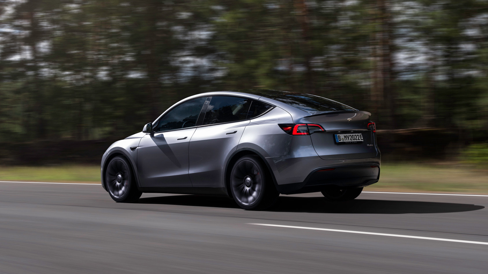 Model Y Quicksilver driving along a forest